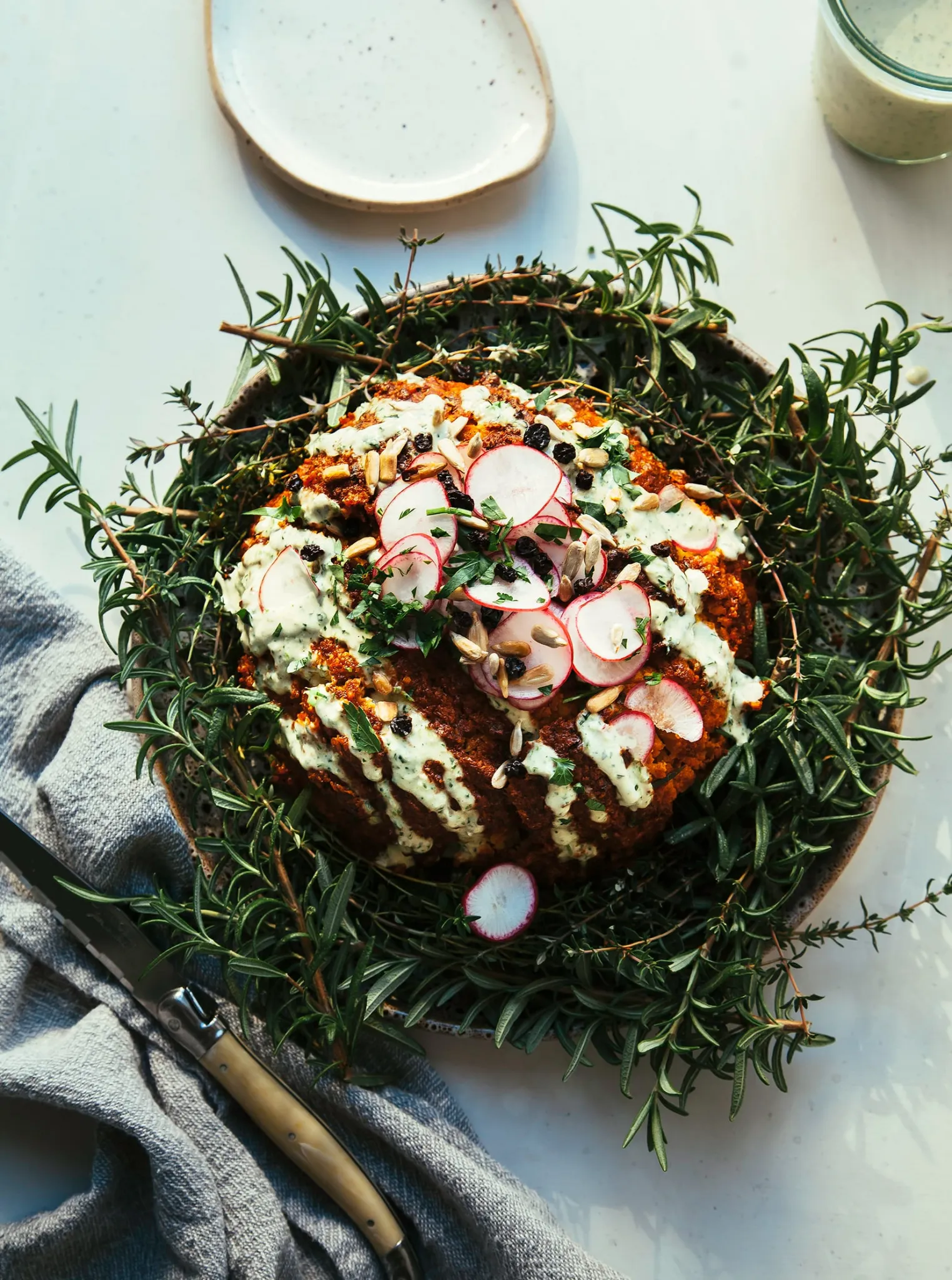 Romesco Roasted Whole Cauliflower with Herbed Tahini Cream